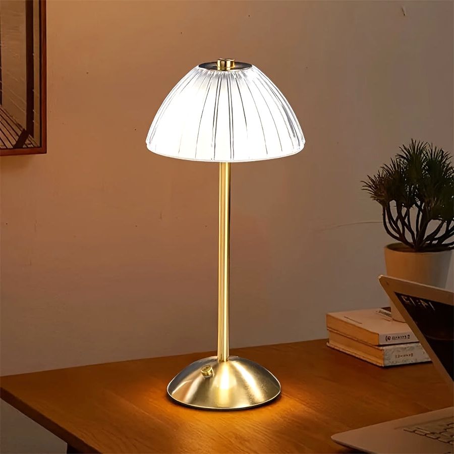 Luxe Glow USB rechargeable table lamp with an elegant gold finish and pleated shade, illuminated on a modern wooden desk.