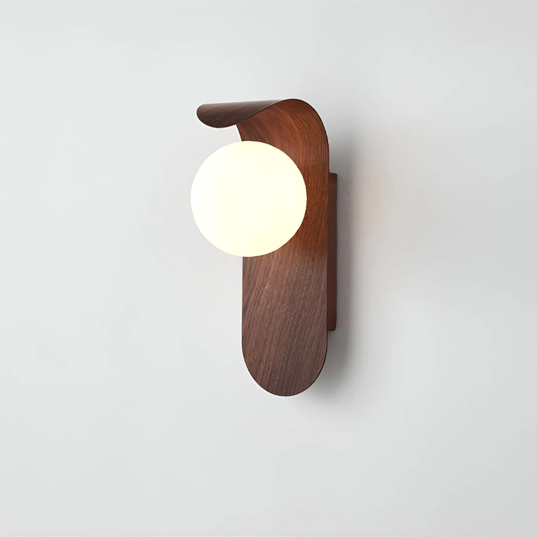 A close-up of the Nordic Glow LED wall sconce in dark walnut wood, illuminated and mounted on a plain white wall, highlighting its minimalist design.